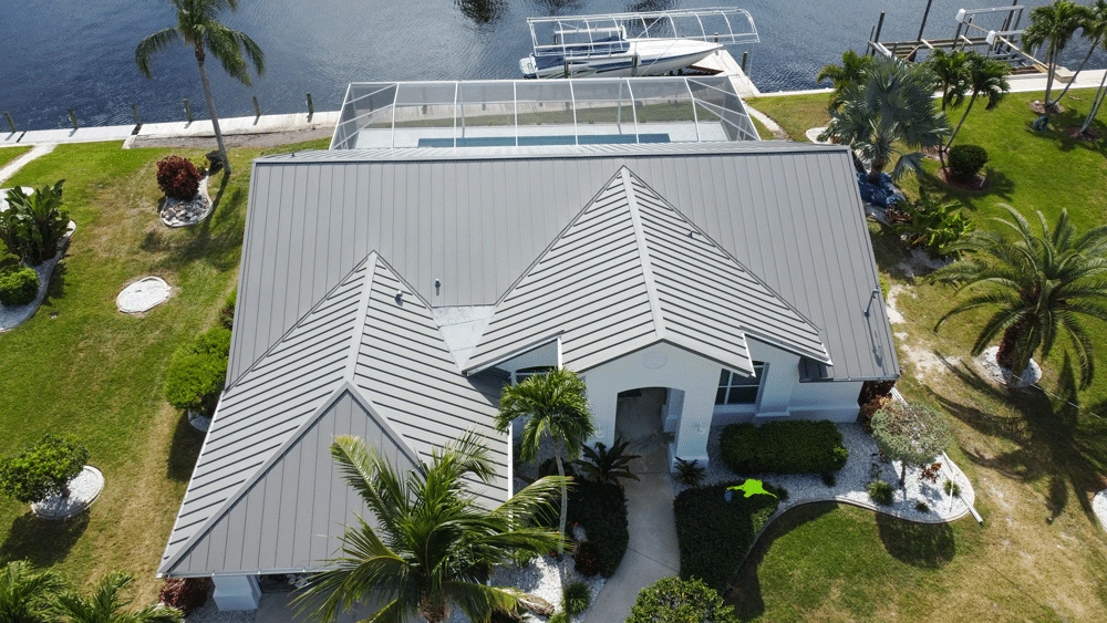 Aerial view of a premium grey standing seam metal roof installed on a waterfront home in Naples, FL by Legrand's Roofing & Construction LLC.