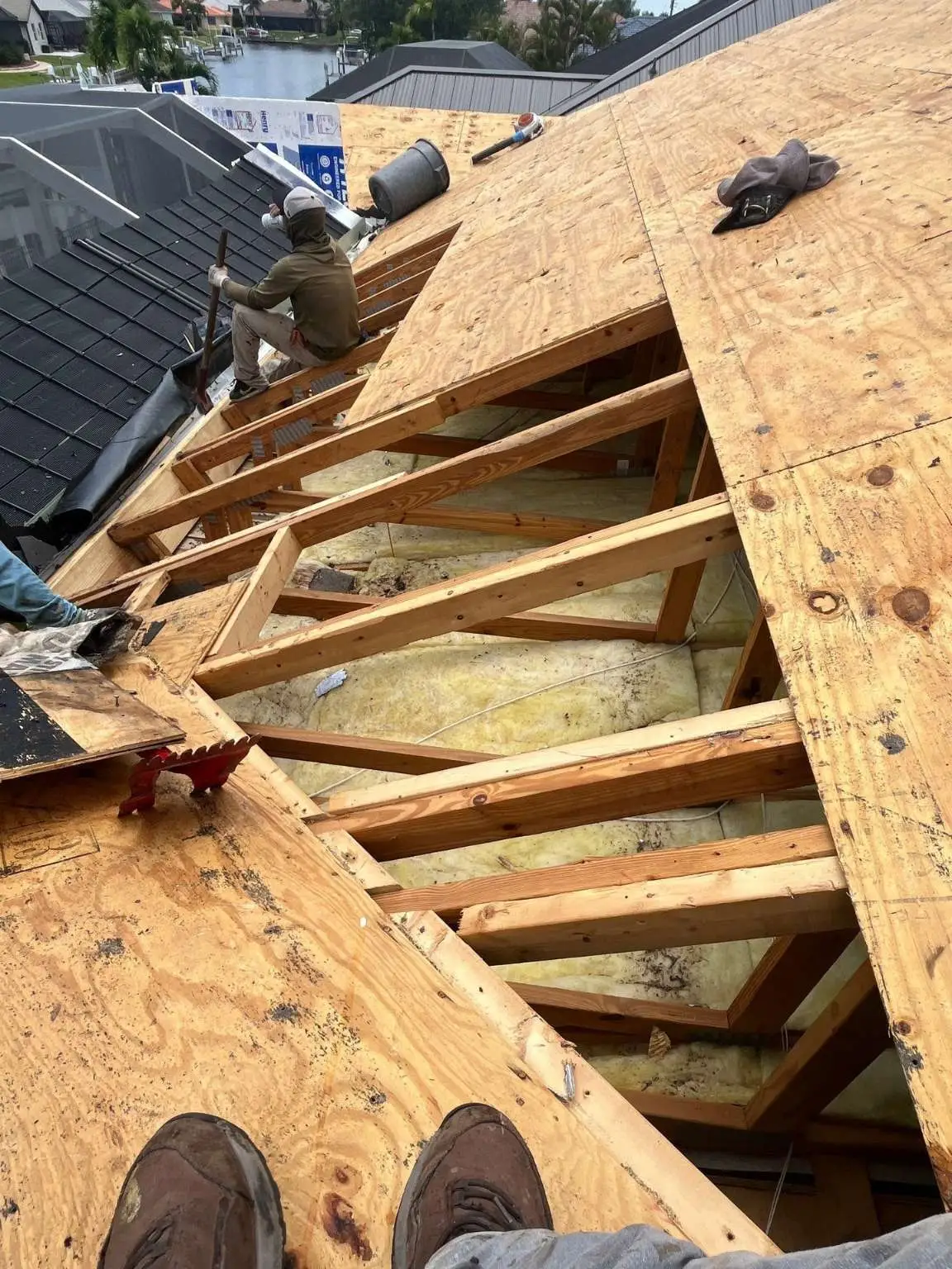 A Legrand's Roofing carpenter repairs exposed structural roof trusses and installs new plywood decking sheathing on the 217 project.