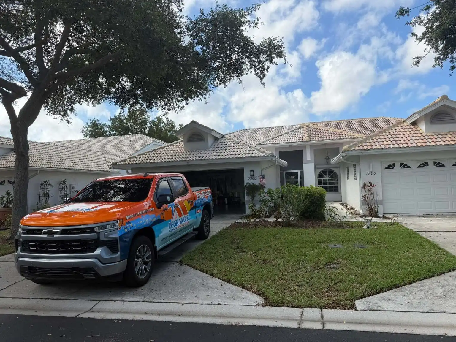 A Legrand's Roofing branded pickup truck parked in the driveway of a residential stucco home with a concrete tile roof during the 2266 project.