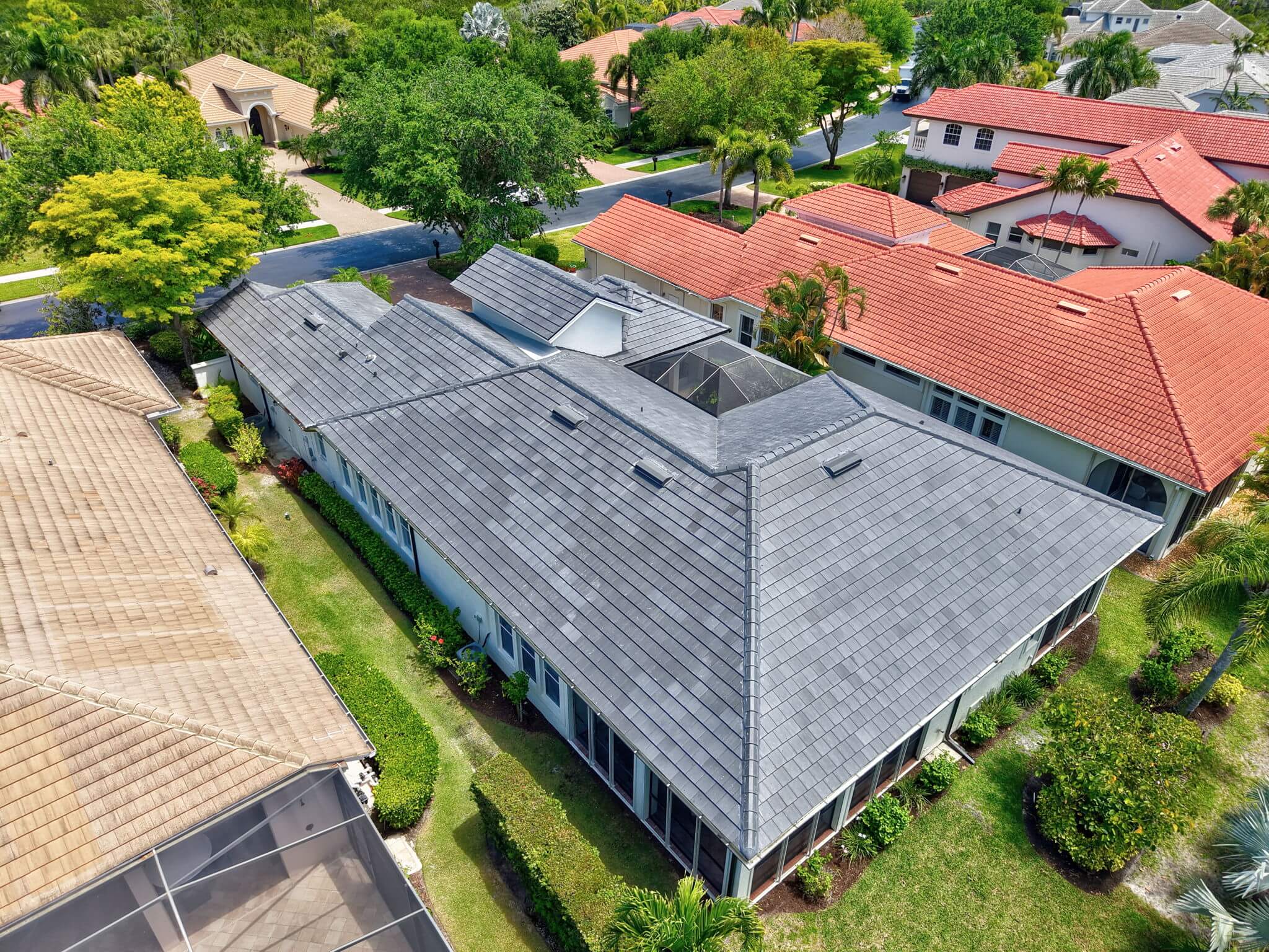 Angled side-aerial perspective emphasizing the long roof pitch, skylight placements, and property borders.