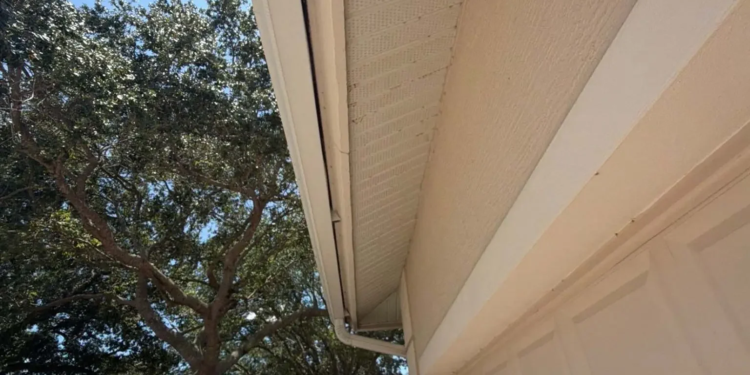 Vented aluminum soffit panels stretching along the side garage roof overhang, inspected by Legrand's Roofing on June 12.