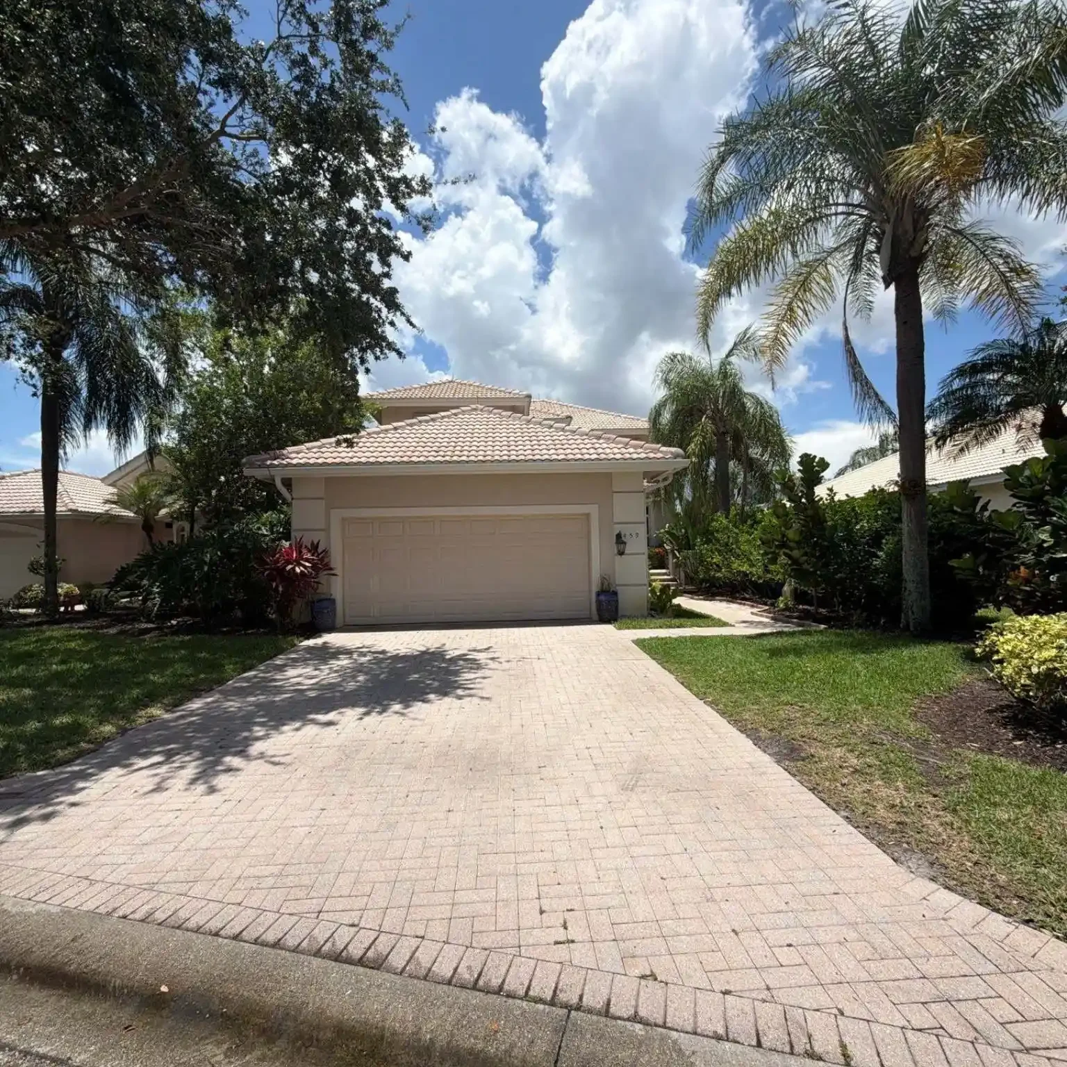Full view of a residential paved driveway leading to a garage section with a classic concrete tile roof system under evaluation on June 12.